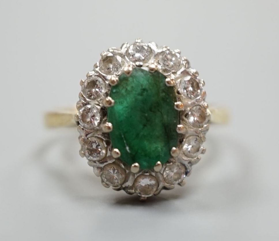 A yellow metal, emerald and diamond set oval cluster ring, size P/Q, gross weight 5 grams.